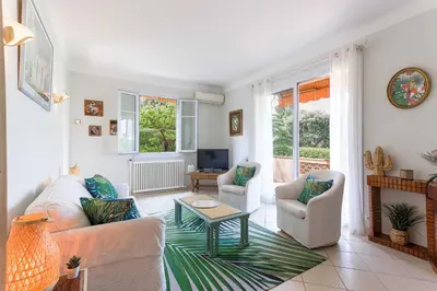 a living room with a couch and two chairs and a table at Villa Les Chênes Verts by Halldis in Le Cannet