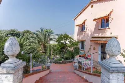 a house with a brick walkway next to a building at Villa Les Chênes Verts by Halldis in Le Cannet