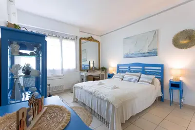 a bedroom with a blue bed and a mirror at Villa Les Chênes Verts by Halldis in Le Cannet