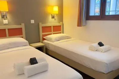 two beds in a hotel room with towels at Vue Mer Azur - Villa France Cannes in Cannes