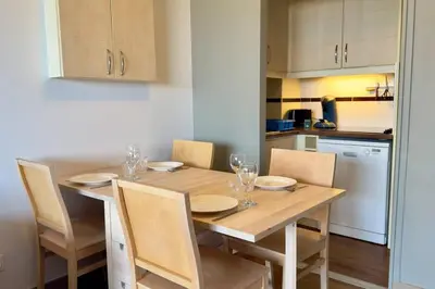 a kitchen with a wooden table with chairs and a dining room at Vue Mer Azur - Villa France Cannes in Cannes