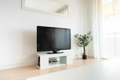 a flat screen tv sitting on a white stand in a living room at Charmant 2 Pièces au Cannet in Le Cannet
