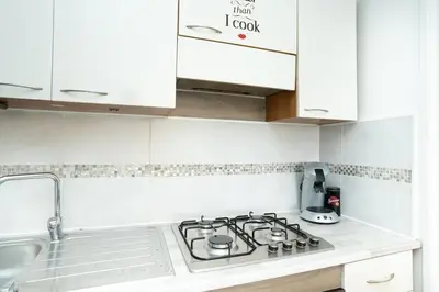 a white kitchen with a stove and a sink at Charmant 2 Pièces au Cannet in Le Cannet