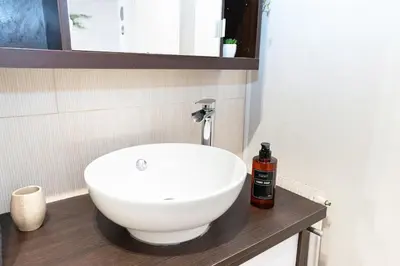 a bathroom with a white sink on a wooden counter at Charmant 2 Pièces au Cannet in Le Cannet