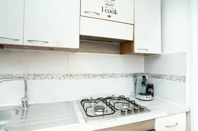 a white kitchen with a stove and a sink at Charmant 2 Pièces au Cannet in Le Cannet