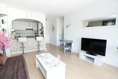 a white living room with a tv and a couch at Charmant 2 Pièces au Cannet in Le Cannet