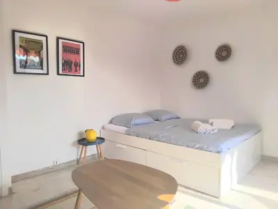 a bedroom with a bed and a wooden table at Beau studio à 5 min de la plage in Cannes
