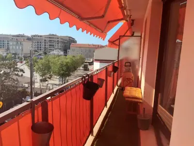 a balcony with red walls and a red fence at Beau studio à 5 min de la plage in Cannes