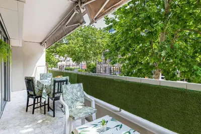a patio with chairs and tables on a balcony at Magnifique appartement proche plages et palais in Cannes