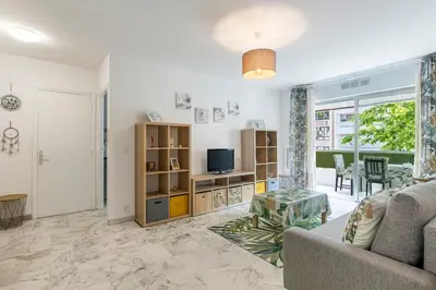 a living room with a couch and a tv at Magnifique appartement proche plages et palais in Cannes