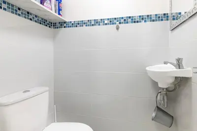 a white bathroom with a toilet and a sink at Magnifique appartement proche plages et palais in Cannes
