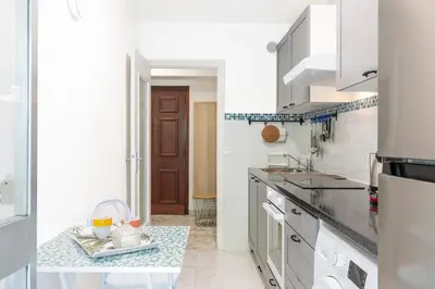 a white kitchen with a sink and a counter at Magnifique appartement proche plages et palais in Cannes