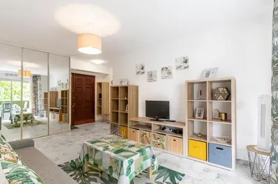 a living room with a couch and a tv at Magnifique appartement proche plages et palais in Cannes