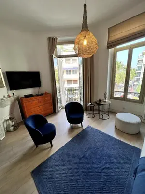 a living room with a blue rug and a chandelier at T2 coeur de Cannes a 2 pas de la croisette in Cannes