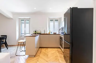 a kitchen with a black refrigerator in a room at Apartment 2 bedrooms near beach - Cannes in Cannes