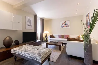 a living room with a white couch and a tv at Notre Dame - Terrace, AC, 3mn from Palais & Beach, modern in Cannes