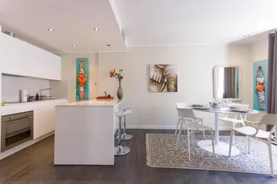 a kitchen and dining room with a table and chairs at Notre Dame - Terrace, AC, 3mn from Palais & Beach, modern in Cannes