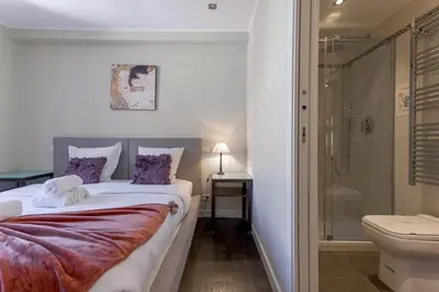 a bedroom with a bed and a shower and a toilet at Notre Dame - Terrace, AC, 3mn from Palais & Beach, modern in Cannes