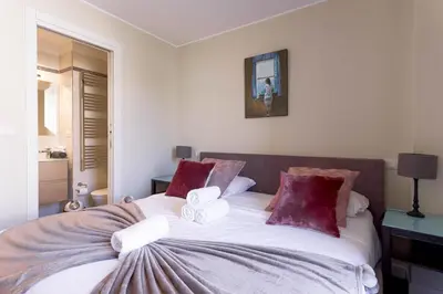 a bedroom with a large bed with red pillows at Notre Dame - Terrace, AC, 3mn from Palais & Beach, modern in Cannes