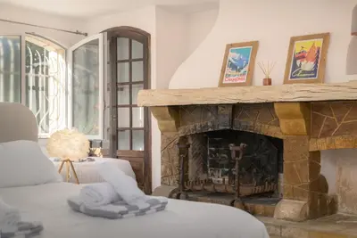 a living room with a fireplace and a couch at Villa Lou San Peyre, Cannes et Mougins, 4 km des plages in Le Cannet