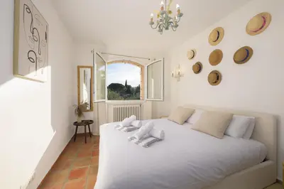 a white bed in a room with a window at Villa Lou San Peyre, Cannes et Mougins, 4 km des plages in Le Cannet