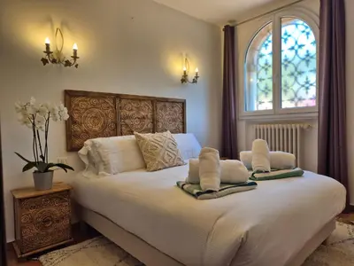 a bedroom with a white bed with two pillows on it at Villa Lou San Peyre, Cannes et Mougins, 4 km des plages in Le Cannet