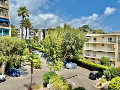 an apartment complex with cars parked in a parking lot at Eden Park in Cannes