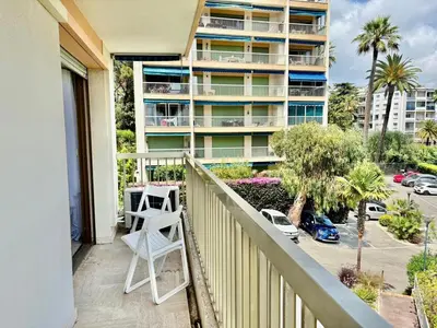 a balcony with a white chair and a building at Eden Park in Cannes