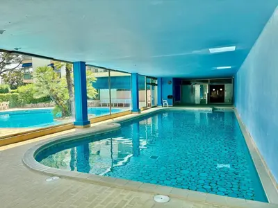 a swimming pool in a building with blue walls at Eden Park in Cannes
