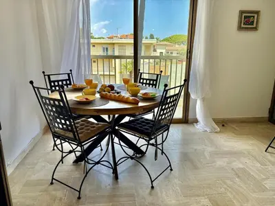 a dining room table with chairs and a view of a balcony at Eden Park in Cannes