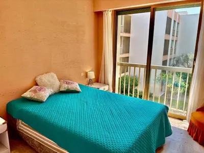 a bedroom with a blue bed with a large window at Eden Park in Cannes