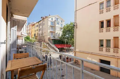 a balcony with a wooden bench and buildings at Immogroom - T2 - 10 min walk from Palais in Cannes
