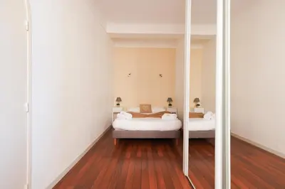 a room with two beds and a mirror at Immogroom - T2 - 10 min walk from Palais in Cannes