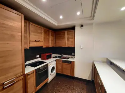 a kitchen with wooden cabinets and a stove top oven at FRGK OXFORD palace park in Cannes