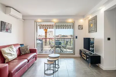a living room with a couch and a tv at L'ÉTOILE D'OR avec terrasse au centre de Cannes in Cannes