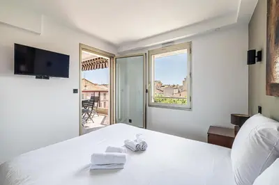 a bedroom with a white bed with towels on it at L'ÉTOILE D'OR avec terrasse au centre de Cannes in Cannes