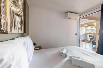 a bedroom with a white bed with towels on it at L'ÉTOILE D'OR avec terrasse au centre de Cannes in Cannes