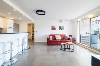 a kitchen and living room with a red couch at L'ÉTOILE D'OR avec terrasse au centre de Cannes in Cannes