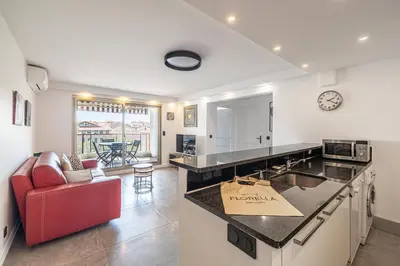 a kitchen with a counter top and a red chair at L'ÉTOILE D'OR avec terrasse au centre de Cannes in Cannes