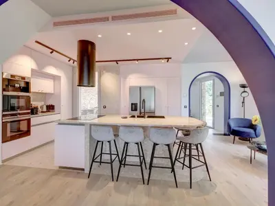 an open kitchen with a large island with bar stools at Immogroom - Amazing Villa with sea view in Vallauris
