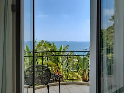 a balcony with a chair and a view of the ocean at Immogroom - Amazing Villa with sea view in Vallauris