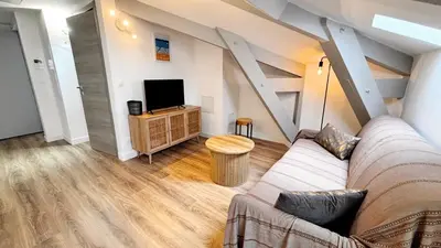 a living room with a couch and a tv at Proche gare, 5min Plage du Midi, T3, 6 personnes By Palmazur Vacances in Cannes