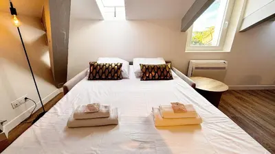 a bedroom with a large white bed with two pillows at Proche gare, 5min Plage du Midi, T3, 6 personnes By Palmazur Vacances in Cannes