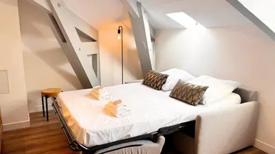 a small bed in a room with an attic at Proche gare, 5min Plage du Midi, T3, 6 personnes By Palmazur Vacances in Cannes