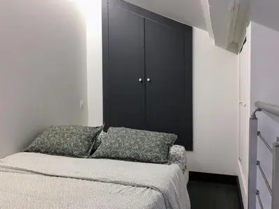 a bedroom with a bed and a black cabinet at Calmette in Cannes