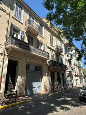an apartment building with a garage on a city street at Calmette in Cannes