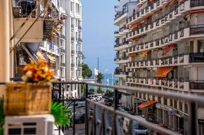 a balcony of a building with a basket of flowers at Luxe 1 minute a pied du Martinez plage shopping vu Mer in Cannes