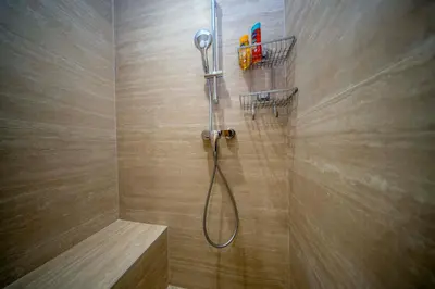 a shower with a shower head in a bathroom at Luxe 1 minute a pied du Martinez plage shopping vu Mer in Cannes