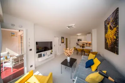 a living room with a blue couch and yellow pillows at Luxe 1 minute a pied du Martinez plage shopping vu Mer in Cannes