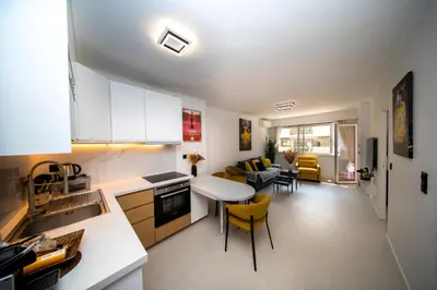 a kitchen and living room with a table and chairs at Luxe 1 minute a pied du Martinez plage shopping vu Mer in Cannes